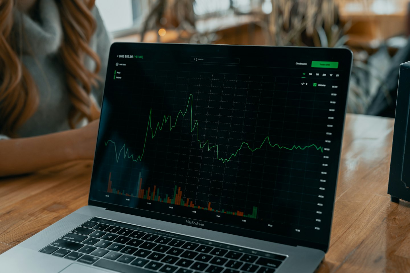 Persona che analizza dati finanziari su uno schermo di laptop.