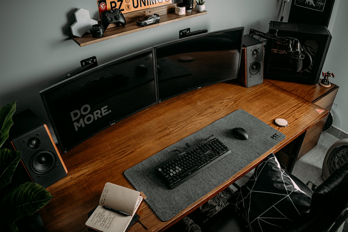 Due monitor con testo motivazionale su una scrivania di legno.